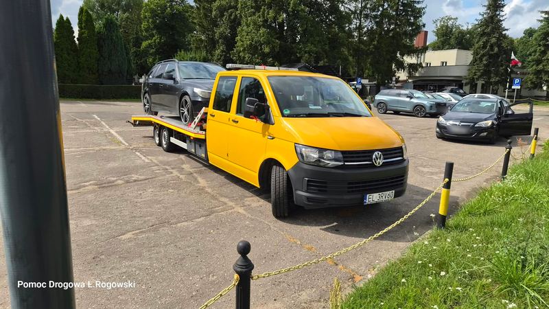 Żółta laweta z samochodem kombi na parkingu — Pomoc Drogowa Łukasz Rogowski